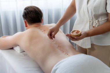 Lüks spa salonunda sıcak mum ışığı atmosferi olan lüks kaplıcalarda deri dökme tedavisi gören mutlu bir adam. Sağlık kaplıcasında güzellik tedavisiyle tuz temizliği. Sessiz.