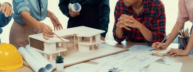 Mimari takım analizi ve ev modeli, plan ve mimari ekipmanlarla toplantı masasında ev inşaatı hakkında beyin fırtınası. Yaratıcı tasarım ve takım çalışması. Filizlenen.