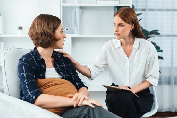 Sad PTSD woman patient in utmost therapy for mental health with psychologist, depression or grief after life failure. Frustrated trauma young woman talking to a psychologist about emotion in clinic
