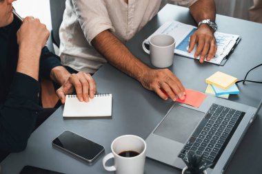 Çeşitli ofis çalışanlarından oluşan bir grup, ofis çalışma alanına yapışkan bir notla stratejik iş pazarlama planlaması üzerine beyin fırtınası yapıyor. İş yerinde olumlu ve verimli bir takım çalışması. Tedbirli.