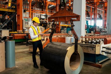 Makine operatörü çelik üretim makinelerini ustalıkla çalıştırıyor, metal fabrikasındaki ağır inşaat mühendisliği malzemeleri için silindir rulo çelik üretiyor. Örnek gösteriliyor