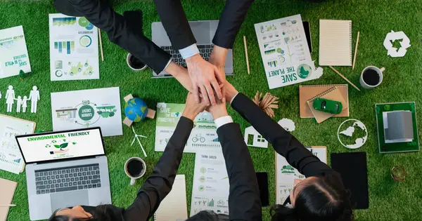 Business synergy in panoramic top view banner of business people holding hand together as team building for eco regulation for environmental protection to contribute sustainable future. Quaint