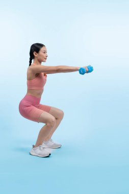 Güçlü enerjik kadın halter kaldırma egzersizi yapıyor izole arka planda. Genç atletik Asyalı kadın dayanıklılığı ve dayanıklılık eğitimi rutin vücut egzersizi..