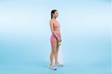 Dinç, enerjik bir kadın izole edilmiş arka planda ağırlık kaldırma egzersizi yapıyor. Genç atletik Asyalı kadın dayanıklılığı ve dayanıklılık eğitimi rutin vücut egzersizi..