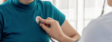 Hasta klinikte ya da hastane ofisinde doktor randevusuna gidiyor. Hastaların nabzını steteskopla kontrol ederken, doktor semptomları muayene ediyor ve teşhis ediyor. Panorama Katı