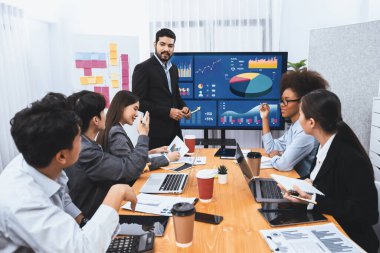 Pazarlama stratejisi için modern toplantıda veri analizi paneli ekranında sunan bir işadamı. Bir grup iş adamıyla konferans odasında iş sunumu. Uyum