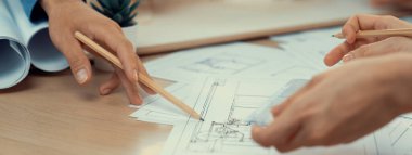 Meslektaşım ev inşaatını ölçüp incelerken kalem kullanarak projeye işaret eden profesyonel mimar el yapımı bir resim. Yaratıcı tasarım ve takım çalışması konsepti. Filizlenen.