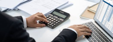 Şirket muhasebecisi, mali verilere dayanarak vergi iadesini hesaplamak ve en yüksek seviyeye çıkarmak ve finansal performansı artırmak için dizüstü bilgisayar üzerinde muhasebe yazılımı kullanır. Panorama 'daki modern muhasebe. Kurnaz.