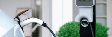 Elektrikli taşıt teknolojisi, EV araba aküsünün şarj edilmesi için konut istasyonunda kullanılıyor. Gelecekteki çevre için temiz ve sürdürülebilir enerji ile çevre dostu ulaşım. Panorama Senkronizasyonu