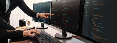 Yazılım geliştirme ekibi ofiste birlikte çalışıyor, bilgisayar ekranında betik görüntülemesi kodluyor. Teknoloji geliştirici şirketinde çalışan programcı ve yazılım mühendisi. Önde.