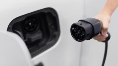 Kameranın önüne odaklanmış EV şarj cihazı fütüristik akıllı dijital EV batarya durum hologramını gösteriyor. EV araba şarjı sürdürülebilir güç için alternatif enerji kullanıyor. İnceleyin
