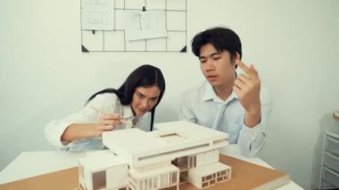 Profesyonel akıllı iş birliği mühendisi mühendis ekibi modern ofisteki ev yapısını planla kontrol ederken genç ve güzel proje yöneticisi not alıyor. Yaratıcı tasarım konsepti. Tertemiz...