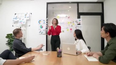 Genç liderin kapanışı, proje hakkında beyin fırtınası yapan meslektaşı ve proje yöneticisi tarafından çevrelenmiş zihin haritası ve renkli yapışkan notlar kullanılarak kendinden emin bir şekilde iş projesini sunuyor. Tertemiz..