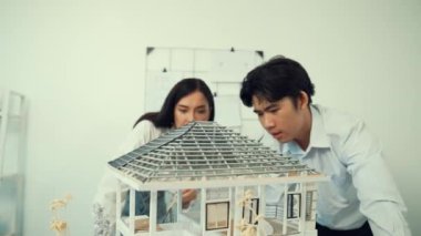 Profesyonel kooperatif beyaz mimar mühendis ekibi ev modelini dikkatle incelerken beyaz modern ofisteki model yapısı hakkında tartışırlar. Yaratıcı karar ve takım çalışması. - Yakın çekim. Tertemiz..