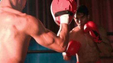Asyalı ve Kafkasyalı Muay Thai boksörü boks antrenmanında boks antrenmanında boks antrenörüne yumruk atma, Muay Thai boks tekniği ve becerilerini sergileme. Impetus