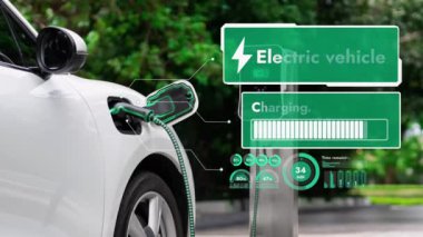 Elektrikli araba, doğal parktaki temiz enerji şarj istasyonundan gelen fütürist akıllı EV şarj cihazının dijital batarya durumu hologramıyla şarj oluyor. Gelecekçi çevre dostu EV araba. İnceleyin
