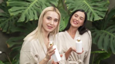 Modern otelde küveti olan tropikal ve egzotik bir spa bahçesi mi yoksa elinde bornozla gezen iki kadın mı yeşil yapraklı, boş zamanların tadını çıkarıyor? Blithe