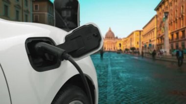 Vatikan 'daki şarj istasyonunda, tarihi Hristiyan kilisesi, şehir merkezinde, ileri düzey elektrikli araba şarj bataryası. EV arabası kablo prizi ile şarj noktasına bağlandı.