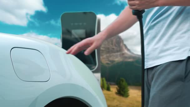 Прогресивна Людина Заряджає Електромобіль Точці Заряджання Подорожуючи Природою Горами Працює — стокове відео