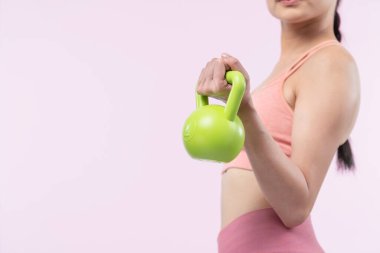 Dinç, enerjik bir kadın izole edilmiş arka planda ağırlık kaldırma egzersizi yapıyor. Genç atletik Asyalı kadın dayanıklılığı ve dayanıklılık eğitimi rutin vücut egzersizi..