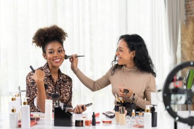 Kadın nüfuzlu kişi canlı yayında video görüntülerini çekiyor. Makyaj çok önemli sosyal medya ya da blog. Kozmetik stüdyosu ışıklandırmalı mutlu genç kız çevrimiçi pazarlama oturumu yayını için..