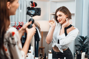 Kadın Etkilenen Vlog video görüntülerini sosyal medya ya da blog 'da en üst düzeyde yayınlıyor. Kozmetik stüdyosu ışıklandırmalı mutlu genç kız çevrimiçi pazarlama oturumu yayını için..