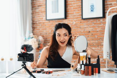 Kadın Etkilenen Vlog video görüntülerini canlı olarak çekiyor. Makyajın çoğu sosyal medya ya da blog 'u anlatıyor. Kozmetik stüdyosu ışıklandırmalı mutlu genç kız çevrimiçi pazarlama oturumu yayını için..