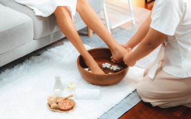 Kadınlar lüks spa salonlarında keyifli ayak masajlarına devam ederken, masör de hafif gün ışığı atmosferinde refleksoloji terapisi veya otel ayak spa 'sında. Sessiz.