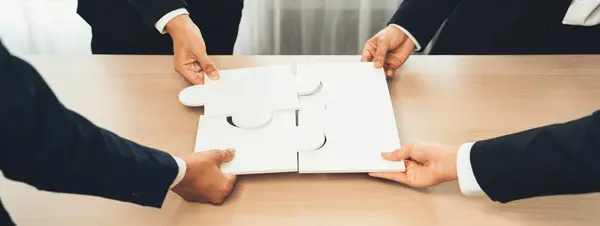 Panorama banner of business team assembling jigsaw puzzle over table symbolize business partnership and collective teamwork for HR recruitment and job seeker background. Shrewd