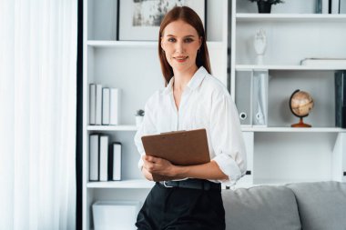 Klinikteki psikolog kadın. Profesyonel portresi. Dostane gülümsemesiyle hastayı psikoloğa davet ediyor. Tecrübeli ve kendine güvenen psikolog son derece uzmandır.
