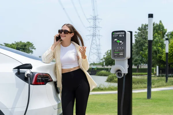 Junge Frau Lädt Elektroauto Batterie Auf Während Sie Einer Ladestation — Stockfoto