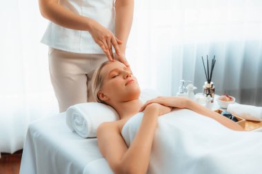 Kafkasyalı kadın stres önleyici kafa masajından ve lüks tatil beldesi ya da otel spa salonundaki modern ışık ortamında yüz güzelliği eğlencelerini şımartmaktan hoşlanıyor. Sessiz.