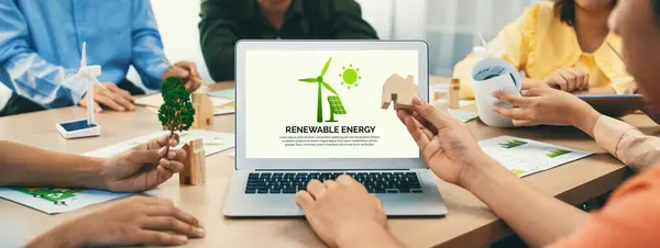 Renewable energy logo displayed on green business laptop while business team represented green design to customer. ESG environment social governance and Eco conservative concept. Closeup. Delineation.