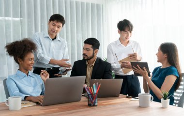 Mutlu iş adamları birlikte çalışır, şirket ofisinde tartışırlar. Profesyonel ve çeşitlilik takım çalışması iş planını bilgisayarda tartışır. Modern çok kültürlü ofis çalışanı. Uyum