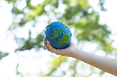 Dünya gezegenini ESG ilkesi ve çevre dostu enerjisiyle daha parlak bir gelecek için Dünya günü olarak el ele tutuşan genç çocuklar. Döngü