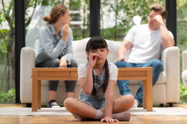 Stresli ve mutsuz bir genç kız oturma odasında ebeveyninin tartışması yüzünden gerginlik içinde ağlıyor. Sağlıksız ev hayatı ve travmatik çocukluk depresyona dönüşür. Eşzamanlama