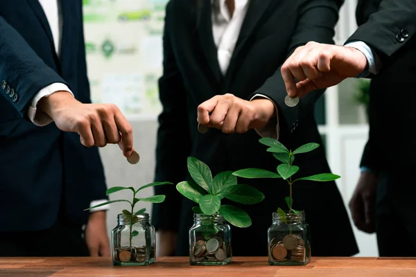 Business people put money saving into jar filled with coins and growing plant for sustainable financial planning for retirement or eco subsidy investment for environment protection. Quaint