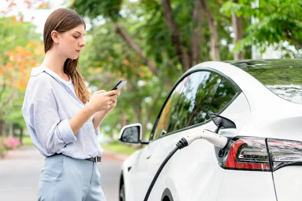 Young Woman Recharge Electric Vehicle Battery Charging Station Using Smartphone — Stock Photo, Image