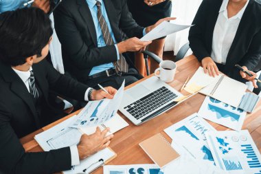 Ofis masasındaki finansal veri raporlarını analiz eden çeşitli bir grup iş analisti. Stratejik pazarlama planlaması için iş istihbarat analizine göre grafikler ve grafikler.