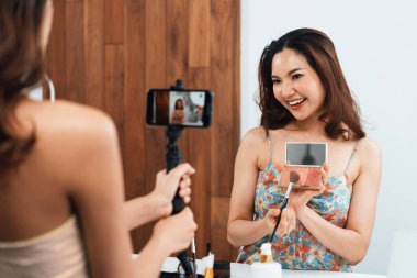 Kadın Etkilenen Vlog video görüntülerini canlı olarak çekiyor. Makyajın çoğu sosyal medya ya da blog 'u anlatıyor. Kozmetik stüdyosu ışıklandırmalı mutlu genç kız çevrimiçi pazarlama oturumu yayını için..