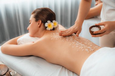 Lüks spa salonlarında sıcak mum ışığında cilt bakımı gören mutlu çift müşterisi. Sağlık kaplıcasında güzellik tedavisiyle tuz temizliği. Sessiz.