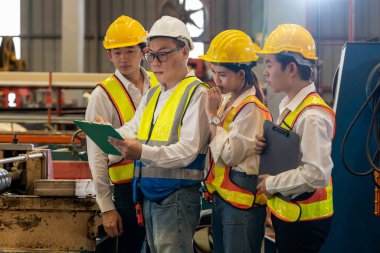 Fabrika ustabaşı ya da denetçisi olan bir grup mühendis eğitim programını denetliyor ya da ağır sanayi fabrikalarındaki metal üretim makinelerinde güvenlik teftişi yapıyor. Örnek gösteriliyor