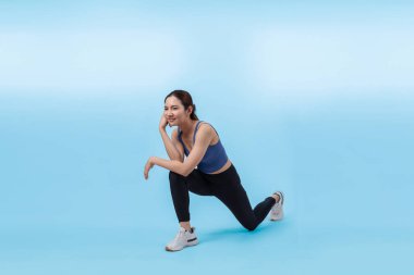Spor giyimli çekici Asyalı kadın spor egzersizlerinden önce esneme hareketleri yapıyor. Stüdyo çekimlerinde ısınan atletik bir kadınla sağlıklı vücut bakımı egzersizi. Kuvvetli