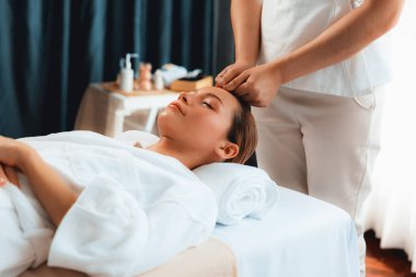 Kafkasyalı kadın stres önleyici kafa masajından ve lüks tatil beldesi ya da otel spa salonundaki modern ışık ortamında yüz güzelliği eğlencelerini şımartmaktan hoşlanıyor. Sessiz.