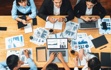 Panorama üst düzey iş analist grubu toplantı masasındaki finansal veri raporunu analiz ediyor. İş zekası analizine göre çizelge ve grafik paneli. Çok titiz.