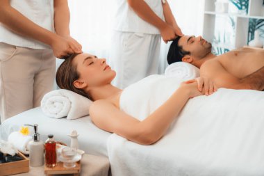 Kafkasyalı çift stres önleyici kafa masajının keyfini çıkarıyor ve lüks otellerde ya da otel spa salonlarında gündüz kaplıcalarında yüz güzelliği eğlencelerini şımartıyor. Sessiz.