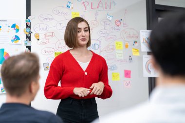 Profesyonel çekici kadın lider, modern iş toplantı odasında beyin fırtınası zihin haritalama istatistikleri ve renkli yapışkan notlar kullanarak yaratıcı pazarlama planını sunuyor. Tertemiz..
