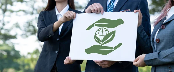 Group of business people stand united, holding eco-friendly idea and concept for environmental awareness campaign embracing eco friendly and greener environment with inspire positive change.Gyre