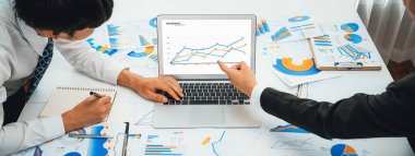 Grup toplantısındaki iş adamları resmi kıyafet paylaşımı fikrine sahipler. Şirketin yaratıcı çalışma alanındaki kar raporunu tartışıyorlar. Grup toplantısı masasında yakın çekim yapmak için. Konuşma .