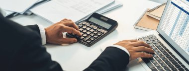 Şirket muhasebecisi, mali verilere dayanarak vergi iadesini hesaplamak ve en yüksek seviyeye çıkarmak ve finansal performansı artırmak için dizüstü bilgisayar üzerinde muhasebe yazılımı kullanır. Panorama 'daki modern muhasebe. Kurnaz.